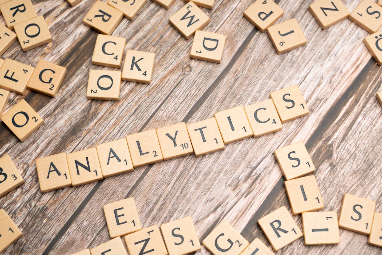 Scrabble tiles spelling Analytics on a wooden surface, symbolizing data analytics concept.